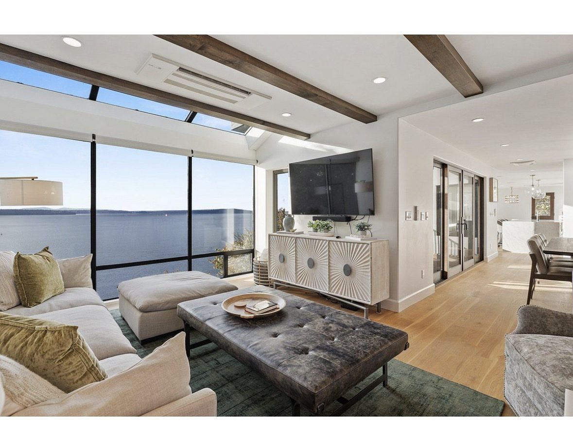 Living room at 4909 SW Othello St with floor-to-ceiling windows over Puget Sound